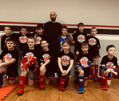 Групповое фото детской секции с тренером в зале