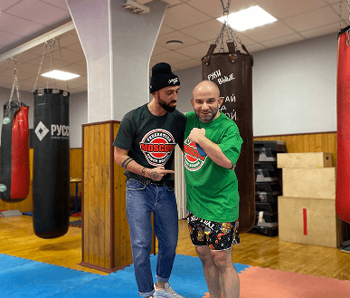 Два тренера в футболках федерации Moscow Khmer Boxing в зале