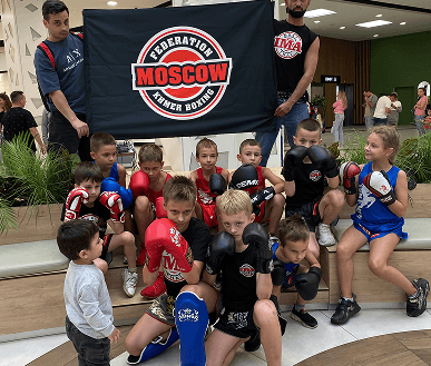 Детская группа с баннером Moscow Khmer Boxing на улице
