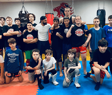 Групповое фото спортсменов разных возрастов в зале